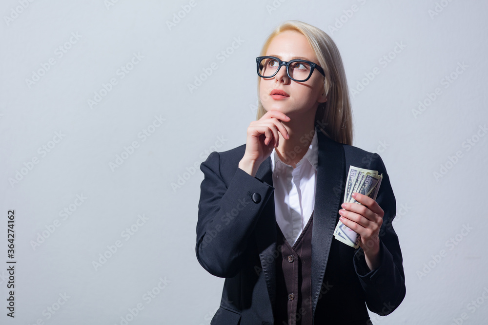 Poster beautiful blonde businesswoman in suit with money on gray background