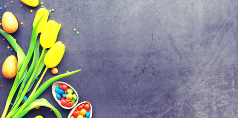 Easter background on black stone. Multicolored eggs and sweet.