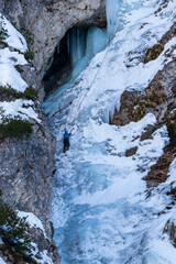 Fototapeta na wymiar Ice frozen waterfall climber ice axe crampons rope winter