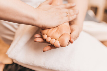 Professional relaxing foot massage - rubbing female feet for blood circulation
