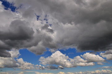 Grey and white clouds against a blue sky.