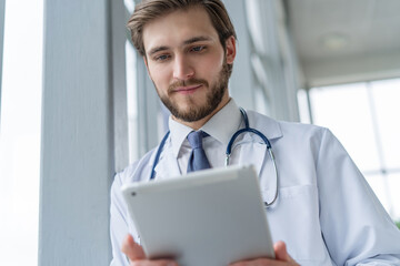 male medical doctor using tablet computer in hospital. - Powered by Adobe