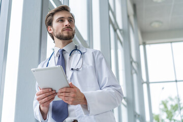 male medical doctor using tablet computer in hospital.