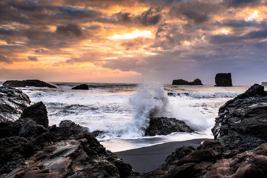 a wave breaks on a rock on the Kirkjufjara coast in Vik, Iceland © joan