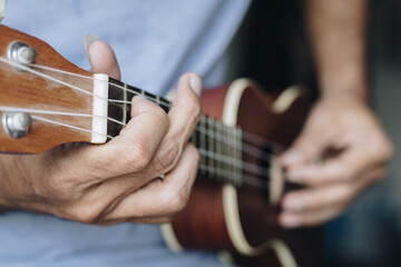 Fototapeta na wymiar Close up Young man playing ukulele