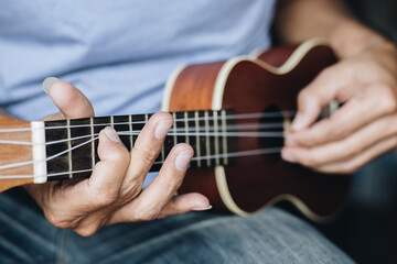 Fototapeta na wymiar Close up Young man playing ukulele