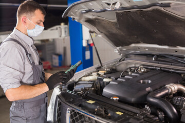 car service worker carries out diagnostics and car repairs in the room.