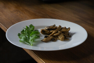 mushrooms in sour cream served with arugula leaves