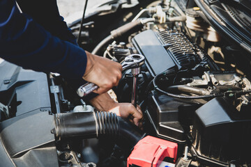 Fototapeta na wymiar Auto mechanic hands using wrench to repair a car engine. concepts of car care fix repair service and insurance.