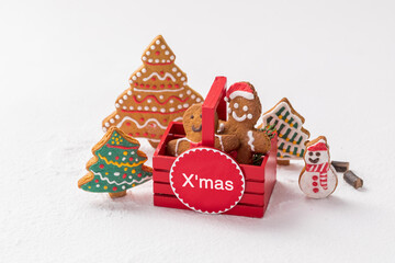 Christmas composition with gingerbread man in a small basket and cookies around it on white backgound.