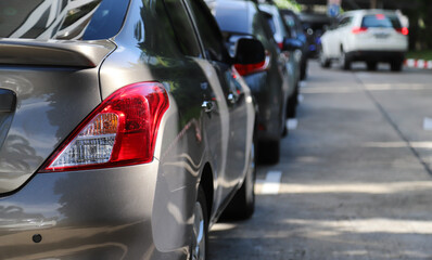 Closeup of rear, back side of brown car with  other cars parking in parking area.
