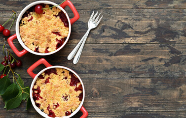 Homemade crumble with cherries and nuts on a wooden background. View from above.