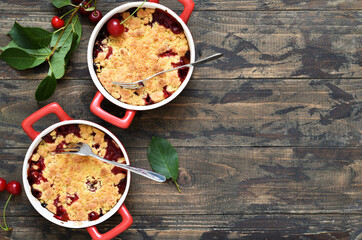 Homemade crumble with cherries and nuts on a wooden background. View from above.