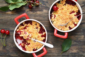 Homemade crumble with cherries and nuts on a wooden background. View from above.