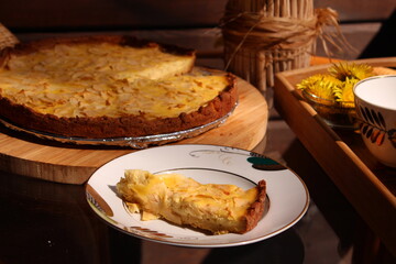A piece of apple tart. The table set for afternoon tea in summer garden.