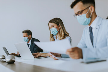 Group of business people have a meeting and working in office and wear masks as protection from corona virus