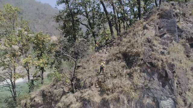  Mountaineers learning how to  climb down a steep cliff or slope  with the help of Rappelling method, in beautiful hills of Himalayas.