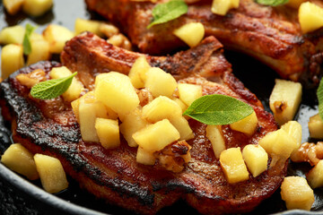 Roasted Pork chops with caramelized apples, walnuts and sage in a cast iron pan