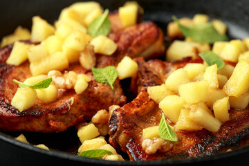 Roasted Pork chops with caramelized apples, walnuts and sage in a cast iron pan