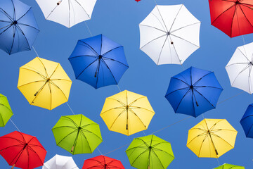 A lot of hanging umbrellas on blue sky background.