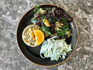 Healthy Organic Vegetarian Plate with Artichoke, Purslane Salad, Yogurt, and Mung Bean Salad, Quinoa Cooked with Olive Oil.