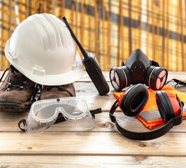 Work safety protection equipment. Industrial protective gear on wooden table, blur construction...