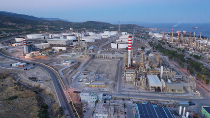 Aerial drone photo of industrial oil and gas plant in Corinth area overlooking Saronic gulf at dusk, Attica, Greece