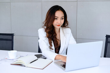 Portrait of a attractive young businesswoman working on a laptop in her workstation