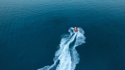 defaultAerial drone photo of stunt man performing extreme stunts with water craft over the ocean at dusk
