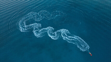 defaultAerial drone photo of stunt man performing extreme stunts with water craft over the ocean at dusk