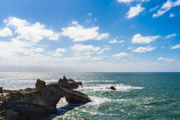 Seascape of Biarritz with rocks over the ocean, blue sky and white clouds. Basque Country of France.