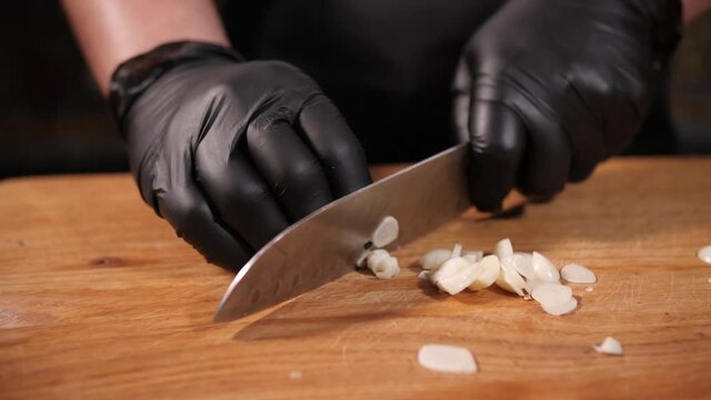 cutting vegetables garlic, cook hands and knife 