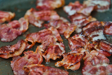 Frühstücksspeck, Schinkenspeck, Bacon beim Anbraten in einer Pfanne, American breackfast