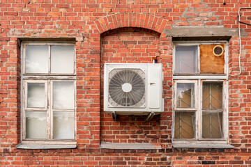 Air conditioning unit on the facade of a old brick house