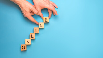 Text ONLINE. Word Online made with wooden cubes on blue background. Online order. E learning....