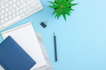 Office desk table with blank notebook, computer, supplies and coffee cup