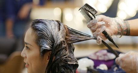 Woman dye her hair at beauty salon