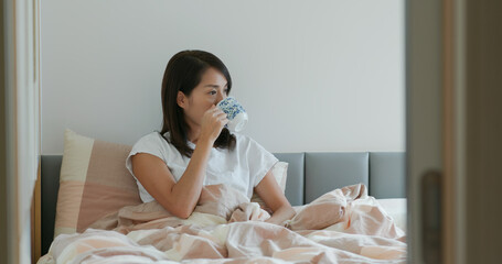 Woman drink of water on bed