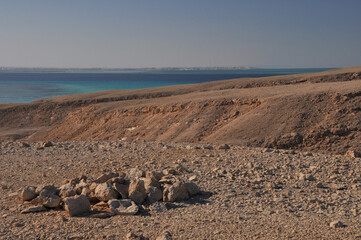 Fototapeta na wymiar Desert island landscape panorama in the Red Sea. On the horizon is the coastline of Hurghada.