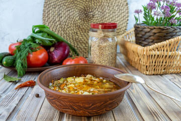 Vegetable soup with pearl barley. Rustic still life.