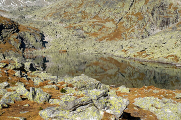 Lake in mountains. Pond in Valley of Five Spis Lakes surrounded by rocky summits, High Tatra Mountains, Slovakia.