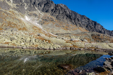 Lake in mountains. Pond in Valley of Five Spis Lakes surrounded by rocky summits, High Tatra Mountains, Slovakia.