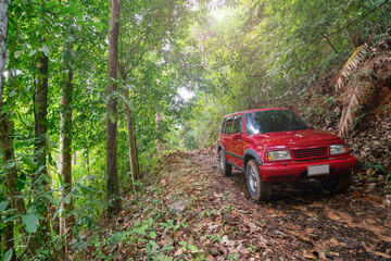 Red suv summer car and road in mountains Driving in forest dirt road Free space for your decoration Green forest background Countryside mood adventure.