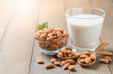 Glass of milk and Almonds nuts on wood background,