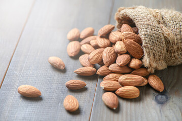Almonds nuts  peeled in sack on wood table.