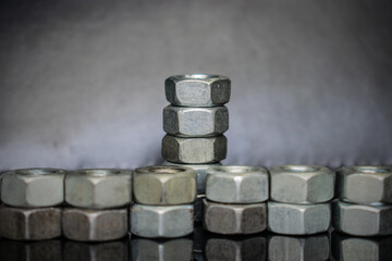 a row of hexagonal nuts with a close-up reflection on a black background