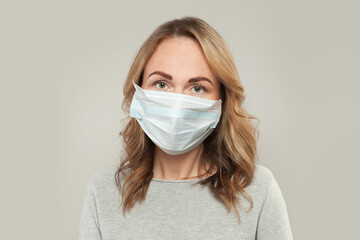 Casual woman in medical protective face mask on white