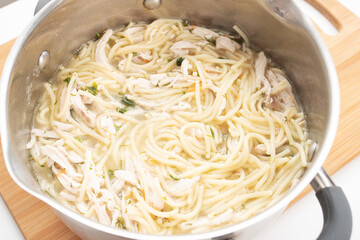 Healthy and wholesome food. Chicken breast noodles with carrots, herbs in a pan