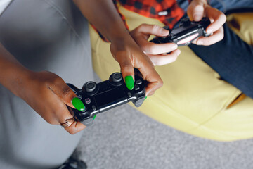 Black girl in a white t-shirt. Couple playing a video games. People use a joystick