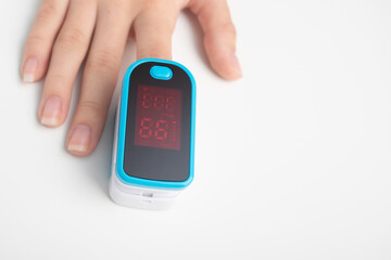 An essential medical device for hypoxia. Female finger in a pulse oximeter